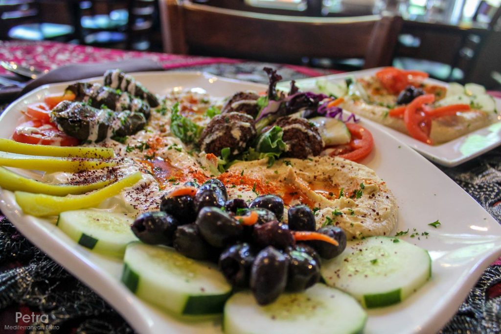 Quite the spread! An appetizer platter with veggies, olives, hummus and other tasty Mediterranean snacks. Photo source.