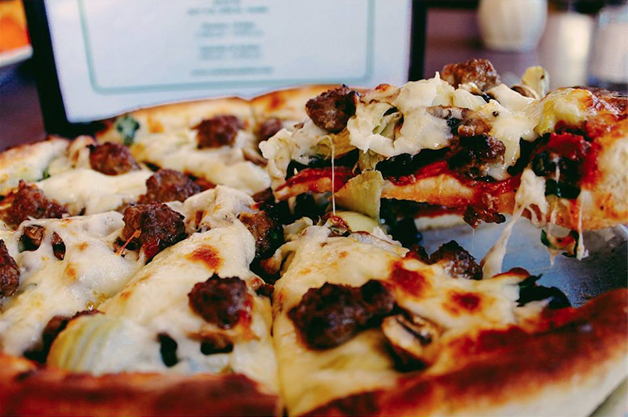 The Nina Special pizza at Varlamos Pizzeria (pepperoni, canadian bacon, artichoke hearts, spinach, black olives, mushrooms & sausage). Photo source. 