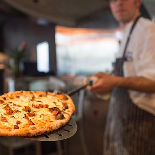 A fresh sourdough pizza is pulled from the woodfired oven at Von's 1000 Spirits. Photo source.